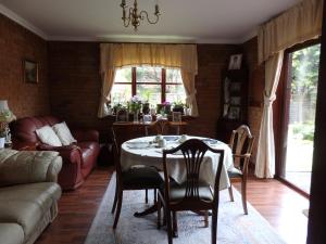 uma sala de estar com uma mesa e um sofá em HayLaneLodge em Solihull
