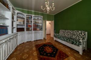 sala de estar con sofá y paredes verdes en La casetta colorata, en Civitavecchia