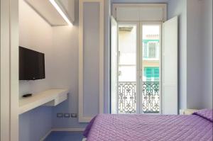 a bedroom with a purple bed and a window at Il Pennello in Amalfi +3 photos