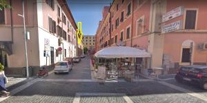 uma rua da cidade com carros estacionados na rua em La casetta colorata em Civitavecchia