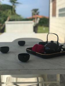 a table with four bowls and a tea kettle on it at Casa Brucoli in Brucoli