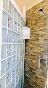 a bathroom with a shower with a stone wall at Casa Brucoli in Brucoli