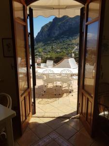 a view of a table and chairs from an open door at Villa del Golfo Urio with swimming pool shared by the two apartments in Santa Flavia