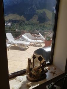 a window with a view of a patio with chairs at Villa del Golfo Urio with swimming pool shared by the two apartments in Santa Flavia