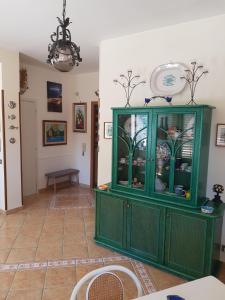 a green cabinet in a room with a table at Villa del Golfo Urio with swimming pool shared by the two apartments in Santa Flavia