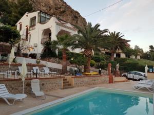 a villa with a swimming pool in front of a house at Villa del Golfo Urio with swimming pool shared by the two apartments it is essential to have a car in Santa Flavia