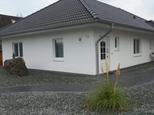 a white house with a rock in front of it at Gemütlich privat allergiearm in Timmendorfer Strand