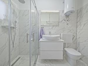 a white bathroom with a sink and a toilet at Apartman Nikica in Postira +32 photos