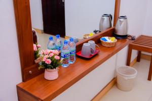 a counter with bottles of water and flowers on it at Homestay Garden Rest Kandy in Kandy