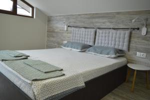a bedroom with a large white bed with pillows at Apartments Dona in Chernomorets