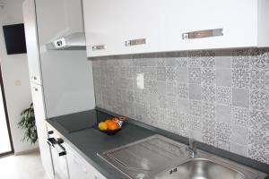 a kitchen with a sink and a bowl of fruit at Guesthouse Santor in Lastovo