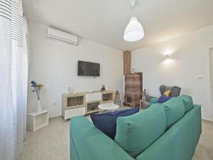 a living room with a blue couch and a tv at Apartman Nikica in Postira