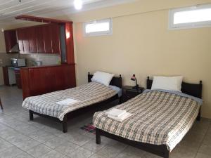 a room with two beds and a kitchen at Nonika’s House in Tsoukalades