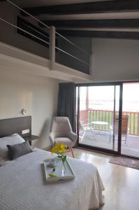 ein Schlafzimmer mit einem Bett mit einem Tisch und einem Stuhl in der Unterkunft Cabanas Da Barcela in Barreiros