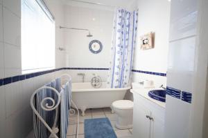 a bathroom with a tub and a toilet and a sink at A Heavenly View in Muizenberg