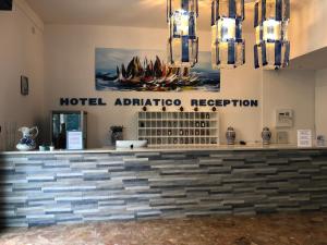 a hotel appliance reception with a sign on the wall at Hotel Adriatico in Bibione