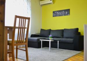 a living room with a couch and a table at Riverside apartment #1. View over Fortress Kastel in Banja Luka