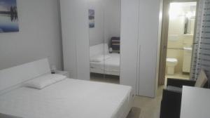 a white bedroom with a bed and a mirror at Zona Maldive del Salento, Spiaggia Sabbiosa a 350 m, 2 Bagni, Clima, Posto Auto Esclusivo in Torre Pali