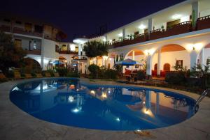 a swimming pool in front of a building at night at Hotel Alegria Nasca in Nazca