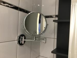 a round mirror on a wall in a bathroom at Apartment 1 mit Terrasse und PKW-Stellplatz in Leverkusen