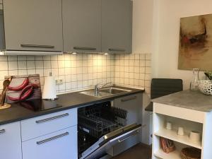 een keuken met witte kasten en een wastafel bij Apartment 1 in Leverkusen