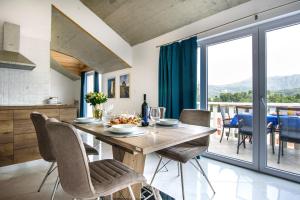 a kitchen and dining room with a wooden table and chairs at California Apartments 3 in Dubrovnik