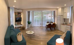 a living room with a blue couch and a kitchen at Butterfly Apartman in Rafailovici