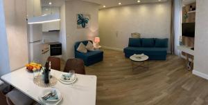 a living room with a blue couch and a table at Butterfly Apartman in Rafailovici