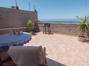 eine Terrasse mit einem Tisch und Meerblick in der Unterkunft Su 'e Torigheddu - Casa con terrazza panoramica in Cuglieri