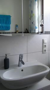 a white sink in a bathroom with a mirror at Gästezimmer Waldblick in Wimbach