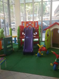 un'area giochi per bambini con giocattoli e scivolo di Hotel De La Plage a Rimini