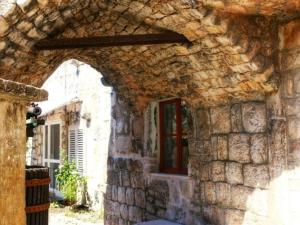 um edifício de pedra com uma janela e um arco em Accommodation Santor em Lastovo