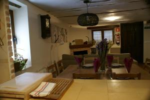 a dining room and living room with a table and chairs at El Pajar de la Abuela in Arcas