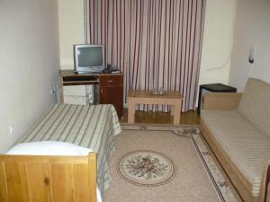 uma sala de estar com duas camas e uma televisão em Hotel Regal em Braila