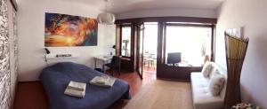 ein Schlafzimmer mit einem Bett, einem Sofa und einem Fenster in der Unterkunft Carcavelos Beach Studio in Lombos