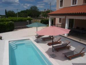 two umbrellas and two chairs and a swimming pool at Danica in Smoljanci