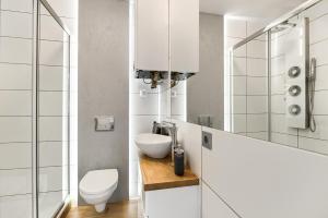 bagno bianco con servizi igienici e lavandino di Toress Apartamenty Deptak a Stettino