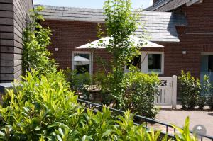 a garden in front of a brick house at Noorden Stuuv in Wittenborn