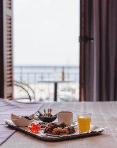 a table with a plate of food and a glass of orange juice at Poseidonio Hotel in Tinos Town