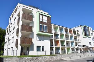 un edificio blanco con balcones en un lateral en Lido Riviéra, Relux Apartman Balatonlelle, en Balatonlelle