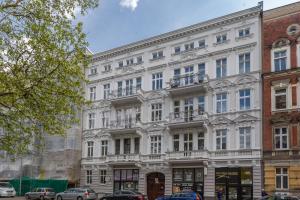 Un edificio blanco con balcones en una calle. en Toress Apartamenty Deptak, en Szczecin