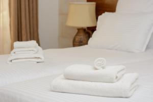 dos pilas de toallas sentadas en una cama en Golden Fleece en Mtskheta