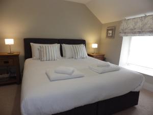 a bedroom with a large white bed with two pillows at Pond Farm in Pickering
