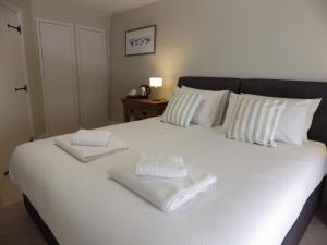 a white bed with two towels on top of it at Pond Farm in Pickering