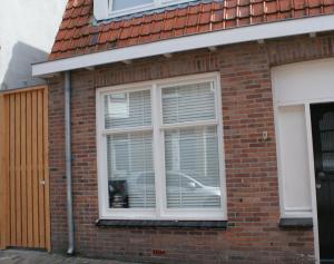ein Fenster mit Jalousien auf einem Backsteinhaus in der Unterkunft Sommarhus in Zandvoort