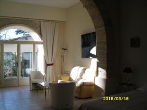 a living room with a couch and a table and chairs at LA CHAPELLE DU PRIEURE in Alignan-du-Vent