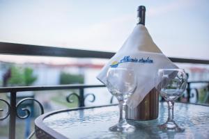 acquablue apartments في كاليثي هالكيديكي: زجاجة من النبيذ وكأسين من النبيذ على الطاولة
