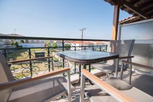 stół i krzesła na balkonie z widokiem w obiekcie acquablue apartments w mieście Kallithea