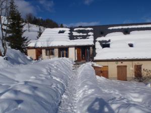 a house covered in snow with a fence at Gîte ROSIDAJEAN in Gresse-en-Vercors