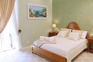a bedroom with a large bed with white sheets at Estlevante B&B in Vieste
